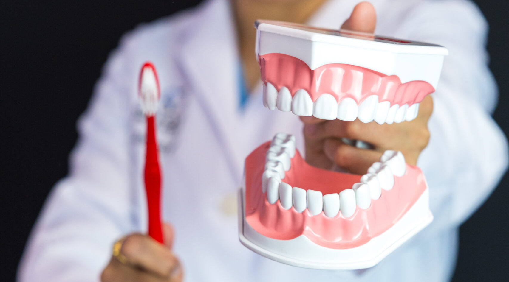 Dr. Patel holding brush and denture