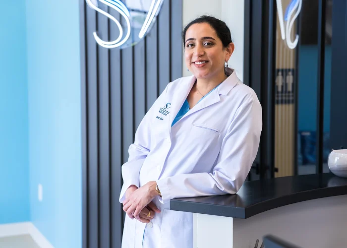 Dr. Khyati Patel standing at the reception of Scioto Smile Studio, warmly smiling